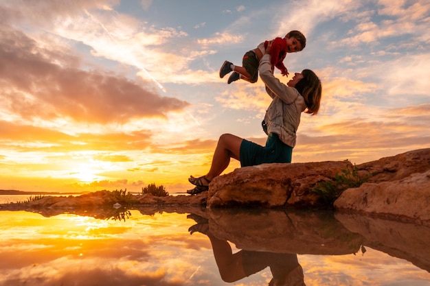 Pôr do sol em Ibiza de férias uma mãe com seu filho se divertindo à beira-mar em San Antonio Abad