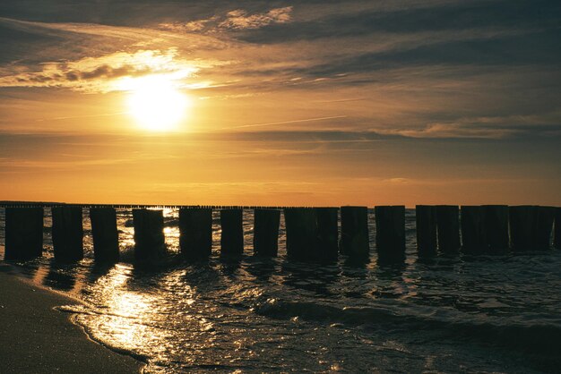 Pôr do sol em Zingst no mar o sol laranja vermelho se põe no horizonte As gaivotas circulam no céu