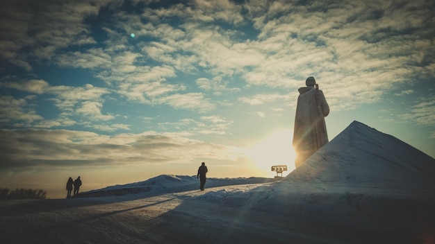 Por do sol gigante Alyosha monumento, Murmansk. Marco em noite nuvens céu.