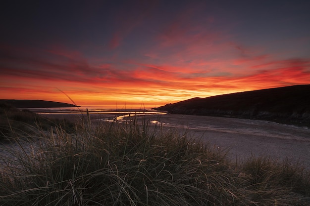 Pôr do sol majestoso sobre o campo em Crantock Bay, Cornwall, Reino Unido