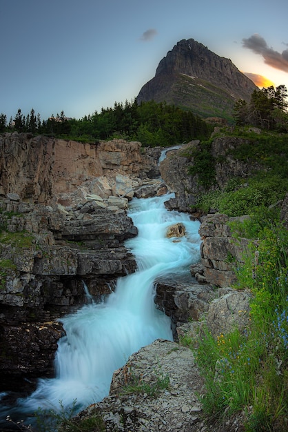 Foto pôr do sol maravilhoso com swiftcurrent falls, parque nacional glacier