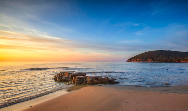 Pôr-do-sol na baía de Cala Violina, praia da Maremma, Toscana, Mar Mediterrâneo, Itália