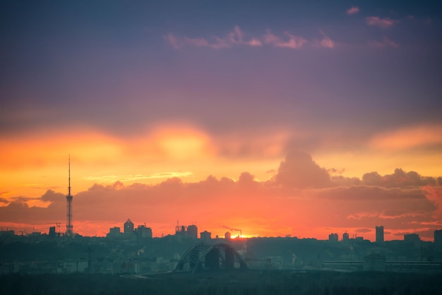 Pôr do sol na cidade com silhueta de edifícios e sol no céu laranja. Kiev, Ucrânia