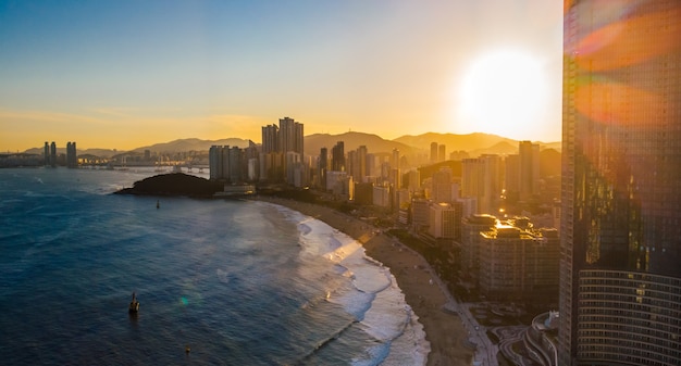 Pôr do sol na cidade moderna de Busan Marine com arranha-céus e o mar