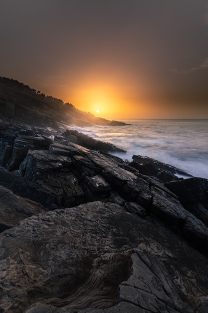 Pôr do sol na costa basca sob a montanha Jaizkibel em Hondarribia, País Basco.