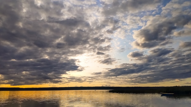 Pôr do sol na costa do lago calmo. Reflexão em uma água