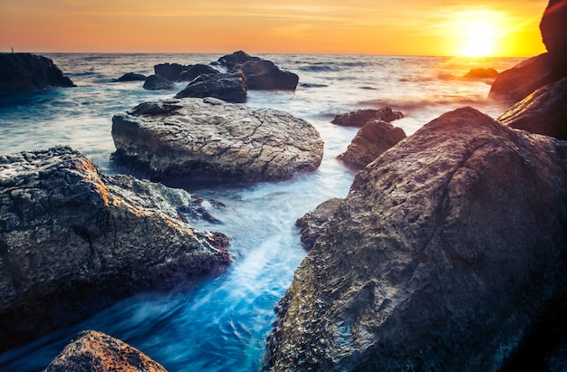 Pôr do sol na costa do sri lanka ao amanhecer com pedras no mundo da beleza em primeiro plano