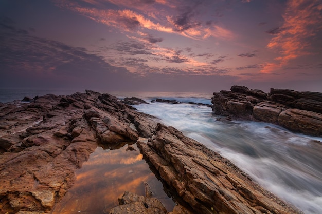 Pôr do sol na costa rochosa de uma ilha tropical