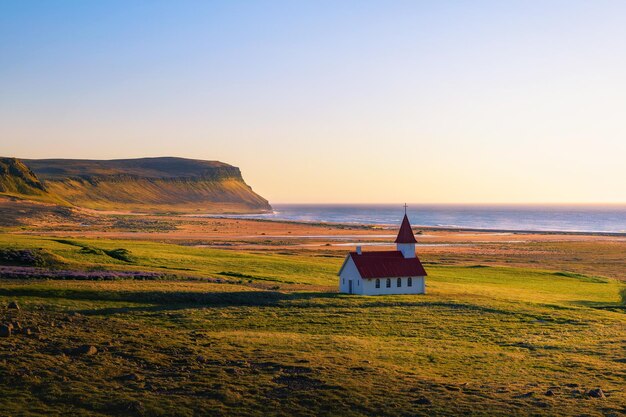 Pôr do sol na igreja Breidavik em Westfjords Islândia