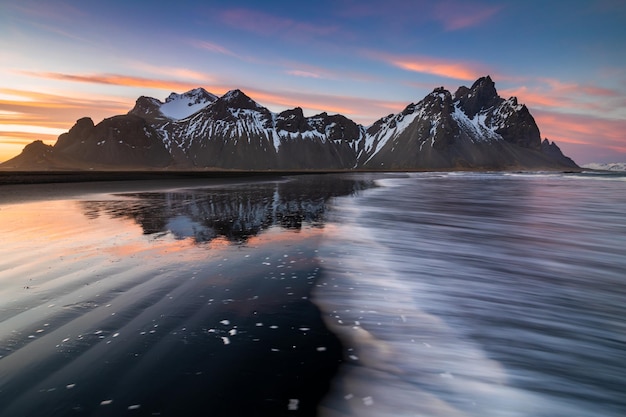 Pôr do sol na montanha de Vestrahorn e na praia de Stokksnes Vestrahorn é uma atração turística popular ao longo do anel viário no leste da Islândia