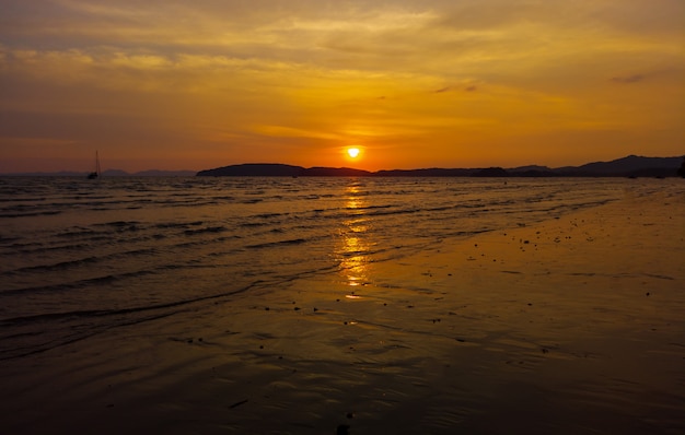 Pôr do sol na praia. A beleza de um nascer do sol tropical de Tailândia da praia na praia.