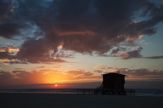 Pôr do sol na praia com céu dramático