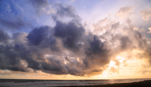 pôr do sol na praia com o céu cheio de nuvens