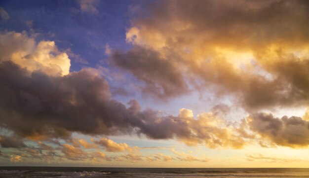 pôr do sol na praia com o céu cheio de nuvens