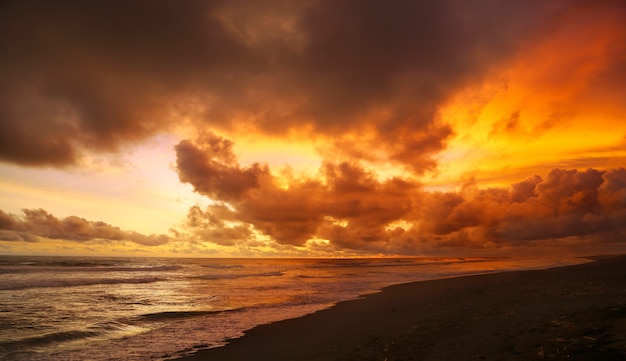 pôr do sol na praia com o céu cheio de nuvens