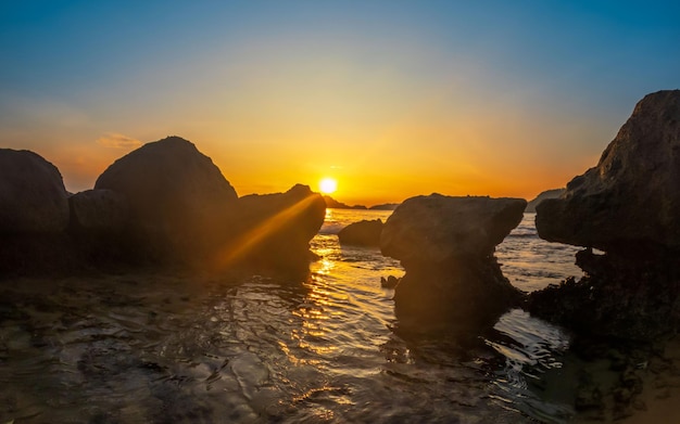 Pôr do sol na praia com o pôr do sol atrás dele