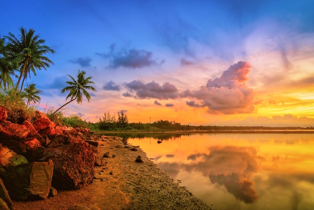 Pôr do sol na praia com palmeira de coco no fundo do céu azul