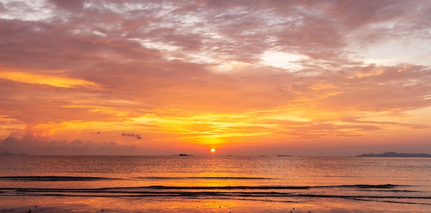 Pôr do sol na praia tropical dourada com céu marinho colorido