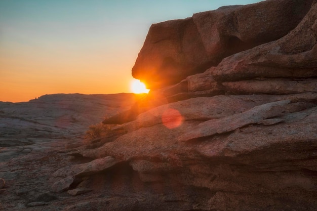 Pôr do sol nas montanhas e rochas do deserto com sol e raios