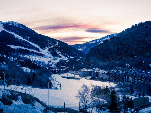 Pôr do sol nevado nas montanhas de Andorra, com pistas de esqui. Conceito de inverno