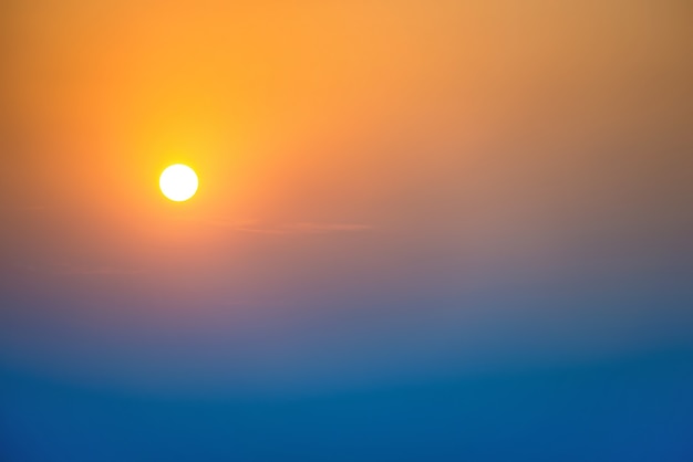 Pôr do sol no céu com grande sol, cores dramáticas de azul, laranja e vermelho