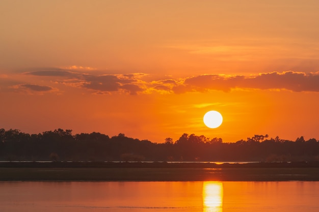 Pôr do sol no lago. por do sol bonito atrás das nuvens acima do fundo excedente da paisagem do lago. céu dramático com nuvem ao pôr do sol