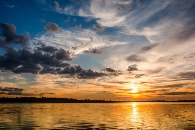 Pôr do sol no lago. por do sol bonito atrás das nuvens acima do fundo excedente da paisagem do lago.