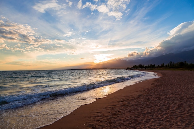 Pôr do sol no mar, belas montanhas e nuvens