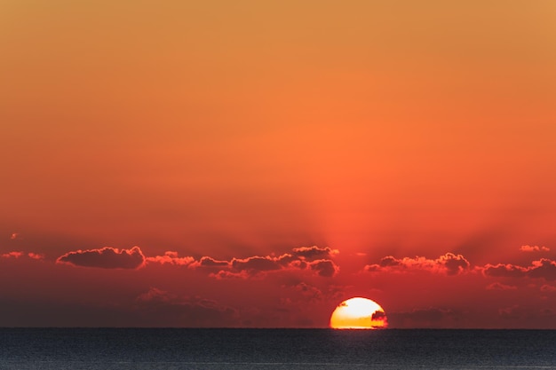 Pôr do sol no mar com nuvens dramáticas.