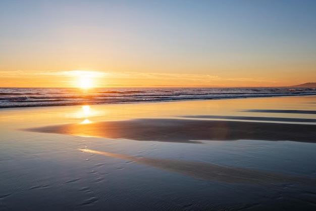 Pôr do sol no Oceano Atlântico com ondas crescentes na praia da Fonte da Telha Costa da Caparica Portugal