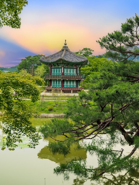 Foto pôr-do-sol no pavilhão hyangwonjeong no centro da lagoa no palácio de gyeongbokgung