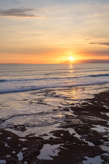 Foto pôr do sol no templo de tanah lot. ilha de bali, indonésia.