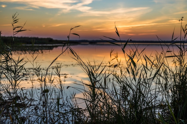 Pôr do sol romântico brilhante crepúsculo sobre o lago.