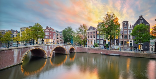 Pôr do sol romântico em Amsterdã Vistas panorâmicas das casas antigas da ponte e do canal Amsterdã Holanda Holanda Europa