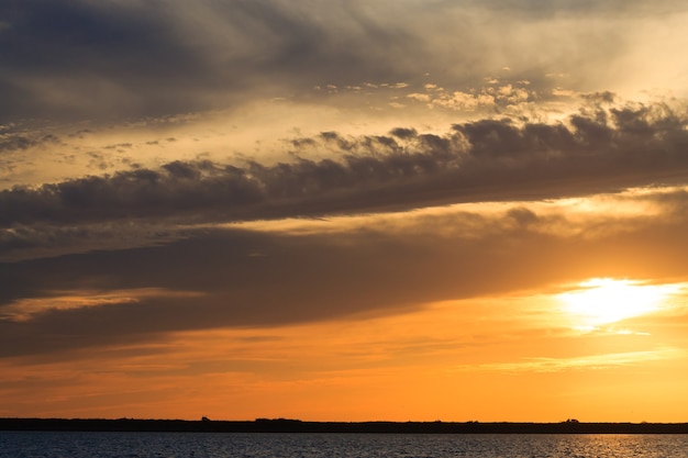 Pôr do sol sobre a água da água e do céu do Delta del Po