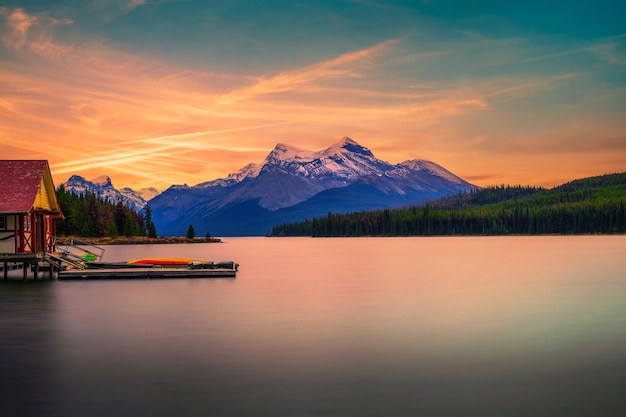 Pôr do sol sobre a casa de barco e o lago maligne no parque nacional jasper canadá