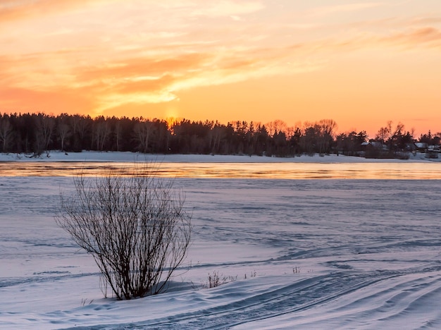 Pôr do sol sobre a costa coberta de neve de Ob