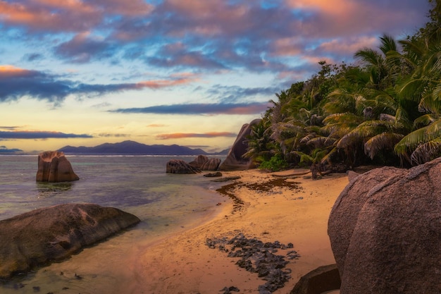 Foto pôr-do-sol sobre a fonte dargent na praia de la digue, ilha das seychelles