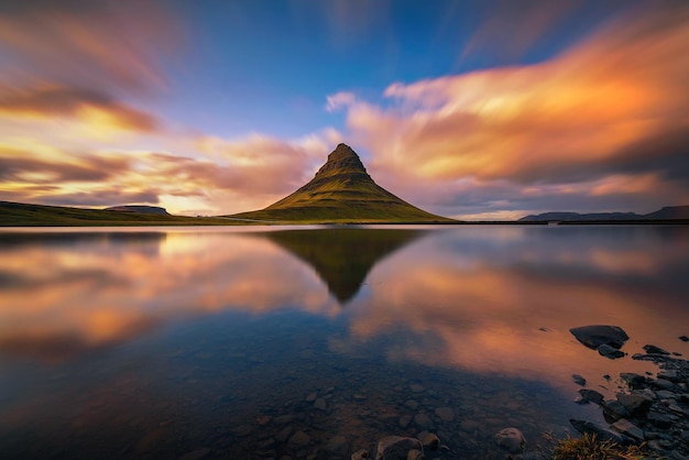 Pôr do sol sobre a montanha Kirkjufell com reflexo em um lago próximo na Islândia