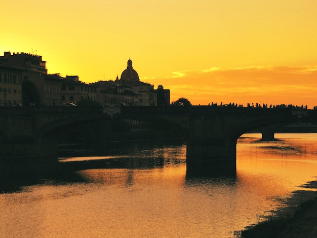 Pôr do sol sobre a Ponte Vecchio é uma ponte medieval sobre o Rio Arno em Florença Itália