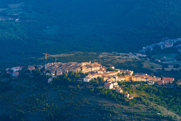 Pôr do sol sobre a vila medieval situada no topo da colina, Abruzzo, Itália. Parque Nacional Gran Sasso, paisagem de montanhas, destino turístico.