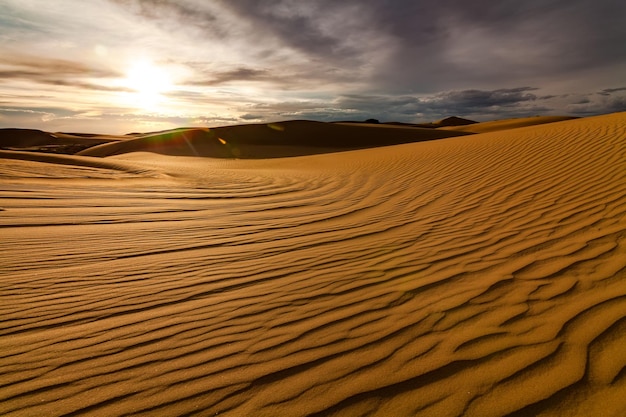 Pôr do sol sobre as dunas de areia no deserto Paisagem árida do deserto do Saara