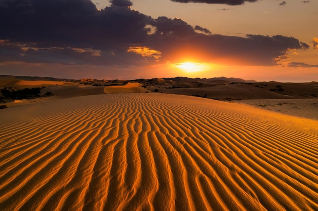 Pôr do sol sobre as dunas de areia no deserto Paisagem árida do deserto do Saara