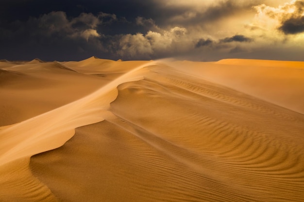 Foto pôr do sol sobre as dunas de areia no deserto paisagem árida do deserto do saara