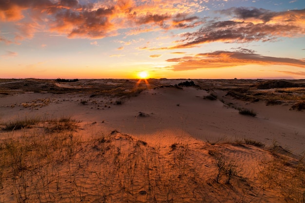 Pôr do sol sobre as dunas de areia no deserto Paisagem árida do deserto do Saara