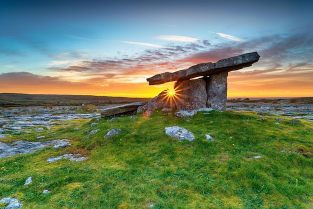 Pôr do sol sobre o dolmen de Poulnabrone, uma antiga tumba de portal em Burren