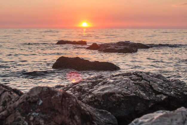 Pôr do sol sobre o mar entre as rochas