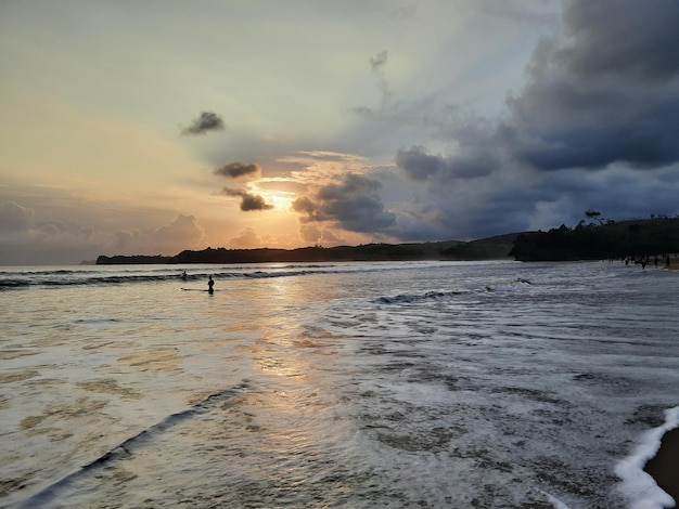 Foto pôr do sol sobre o oceano e céu nublado