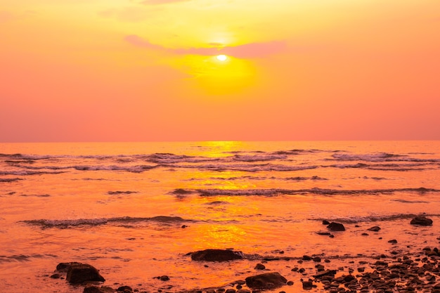 Pôr do sol vermelho-amarelado no mar no verão, na costa