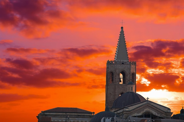 Pôr do sol vermelho com nuvens sobre o campanário de Alghero